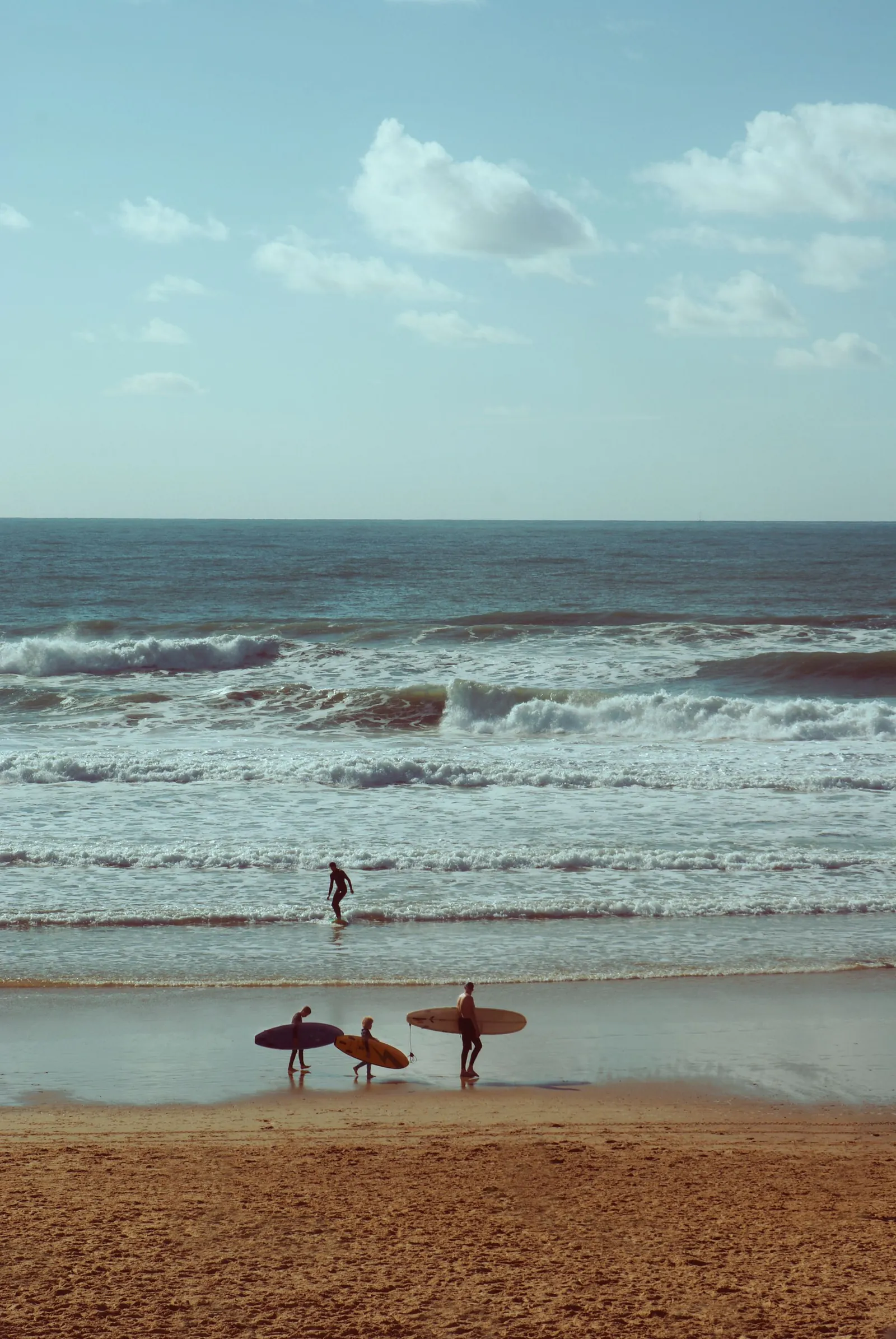 Des surfeurs et des promeneurs sur la plage de Lacanau