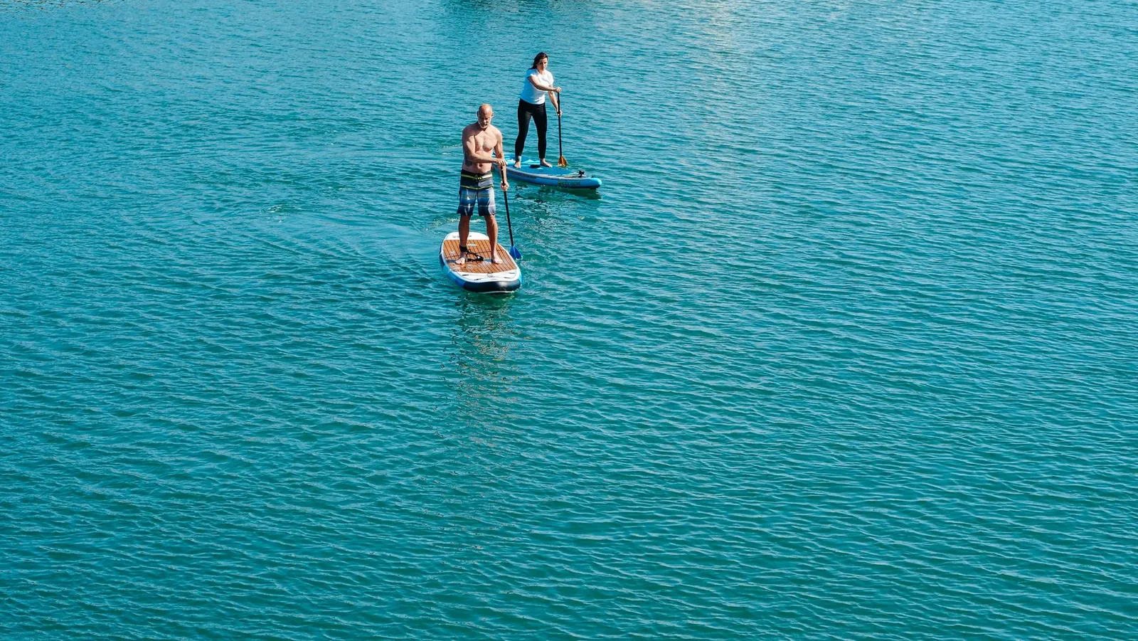 Deux personnes debout sur des planches de stand up paddle