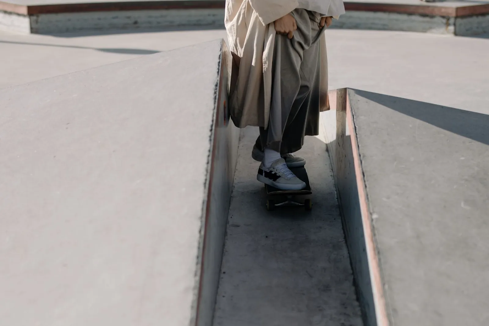Un skateboardeur traverse les courbes d’un skatepark